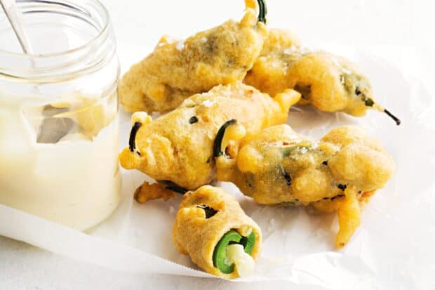 Crispy jalapeno bites stuffed with cheese served next to a jar of dipping sauce, 2K Desktop Wallpaper