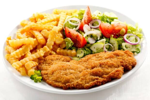 A plate of crispy fried chicken with crinkle cut fries and fresh salad including tomatoes and onions, HD Desktop Wallpaper