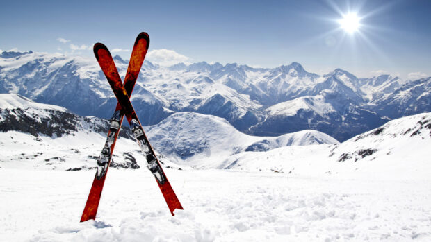 A pair of skiing equipment standing in fresh snow with mountain range in the background, HD Desktop Wallpaper