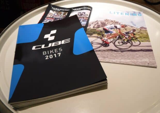 The Cube Bikes 2017 catalog lies open on a table with cycling brochures, Cube Bikes Wallpapers, HD Desktop Wallpaper