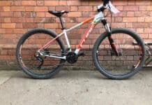 A Cube Bikes mountain bike stands against a brick wall outdoors, HD Desktop Wallpaper