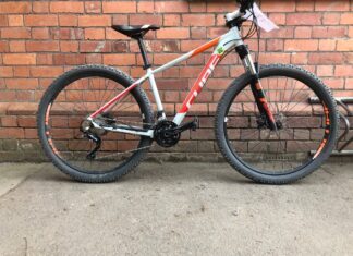 A Cube Bikes mountain bike stands against a brick wall outdoors, HD Desktop Wallpaper