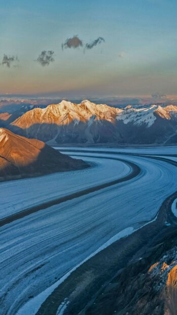 A curved glacier stretches through the mountain range at sunset showcasing glacier wallpapers, 4K Phone Wallpaper