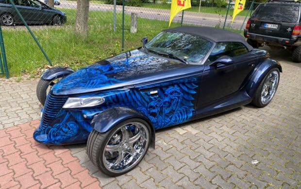 A blue Plymouth Prowler features detailed skull themed artwork on the side panels, HD Desktop Wallpaper