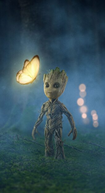 A small Groot stands on mossy ground with a glowing butterfly flying near him, 2K Phone Wallpaper