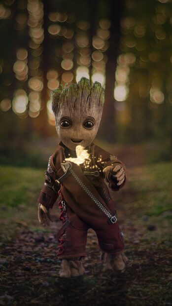 Baby Groot dressed in leather suit holding a glowing butterfly in a forest, 2K Mobile Wallpaper