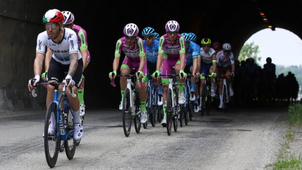 A group of cyclists racing through a tunnel with Bmc Bikes in focus, HD Desktop Wallpaper