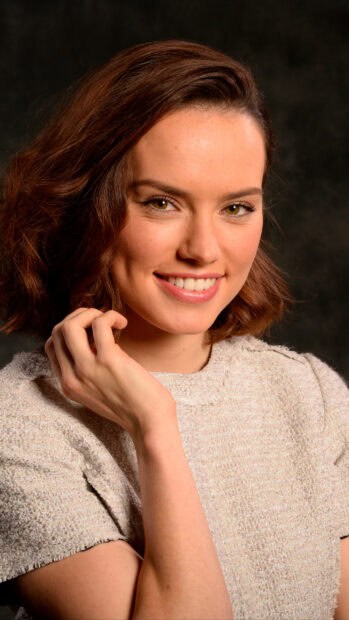Daisy Ridley smiles gently in a close up portrait with soft lighting, 2K Mobile Wallpaper