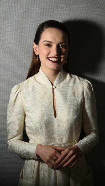 Daisy Ridley wears a cream textured dress and smiles warmly while posing indoors, 4K Phone Wallpaper