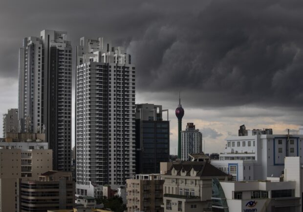 Dark clouds gather above high rise buildings in Colombo Sri Lanka, 2K Desktop Wallpaper