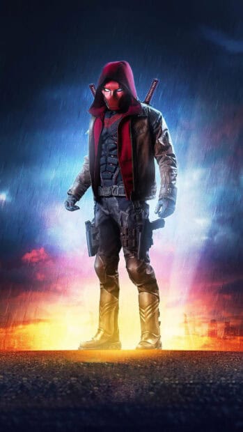 A dark vigilante from Titans Tv Series stands ready with weapons on a rainy night, 4K Phone Wallpaper