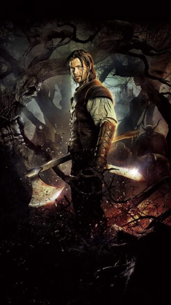 The huntsman stands ready in a dark forest scene from Snow White and the Huntsman, 2K Phone Wallpaper
