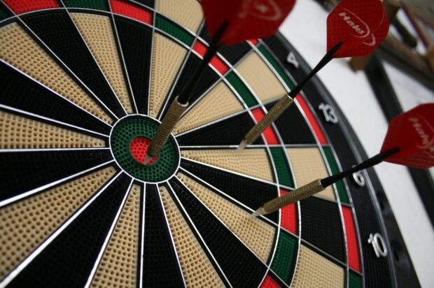 A close up of darts hitting the bullseye on the dartboard in a game of darts wallpapers, HD Desktop Wallpaper