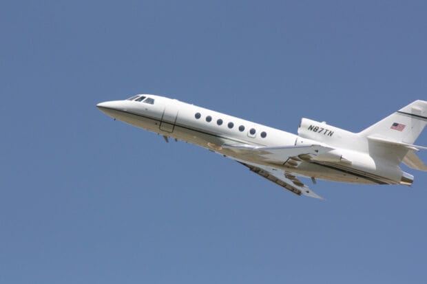 A Dassault Falcon 50 jet flies smoothly in a clear blue sky, HD Desktop Wallpaper
