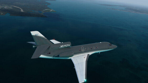 A Dassault Falcon 50 is flying above the ocean near a coastline during daytime, 4K Desktop Wallpaper
