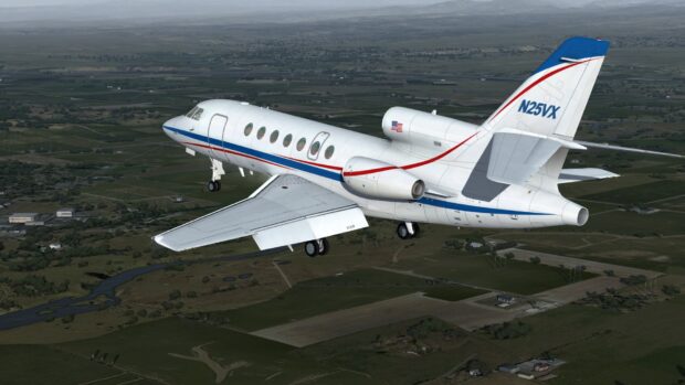 A Dassault Falcon 50 jet is captured flying above a rural landscape with fields and small buildings, HD Desktop Wallpaper