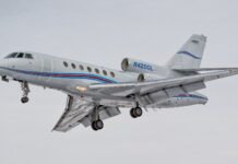 A Dassault Falcon 50 is captured flying with landing gear extended against a gray sky, HD Desktop Wallpaper