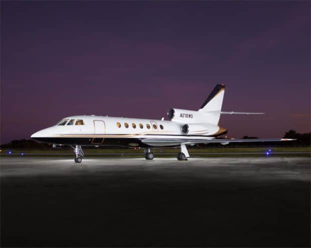 A Dassault Falcon 50 jet is parked on the runway under a purple evening sky, HD Desktop Wallpaper