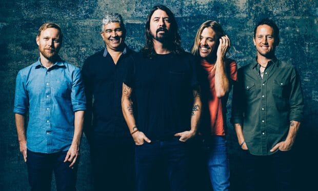 Dave Grohl and his band smiling together in front of a textured wall, HD Desktop Wallpaper