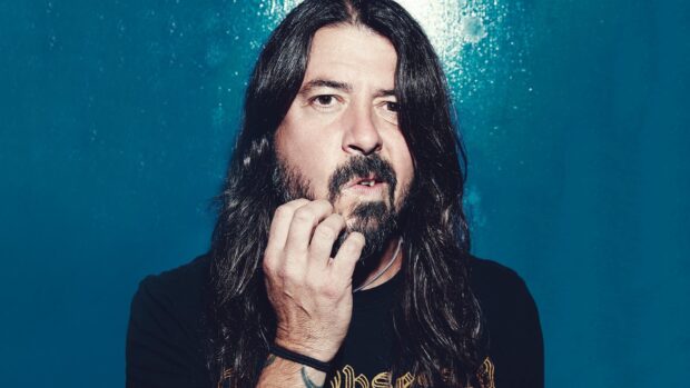 Dave Grohl with long hair and beard posing against blue background, HD Desktop Wallpaper
