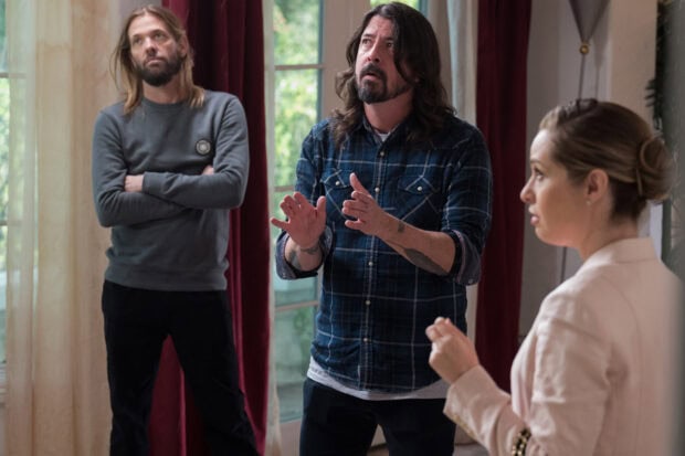 Dave Grohl is engaged in a serious discussion with two people indoors, HD Desktop Wallpaper