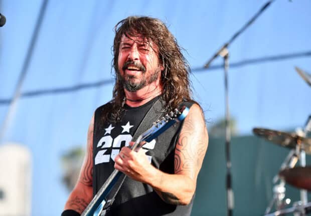 Dave Grohl passionately playing guitar during outdoor concert, 2K Desktop Wallpaper