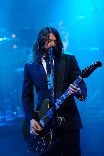 Dave Grohl is playing guitar and singing during a live concert, HD Phone Wallpaper