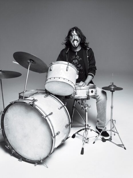 Dave Grohl is sitting behind a drum set sticking out his tongue, HD Desktop Wallpaper