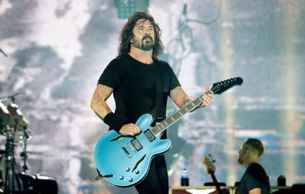 Dave Grohl is performing on stage playing a blue electric guitar with intensity, HD Desktop Wallpaper