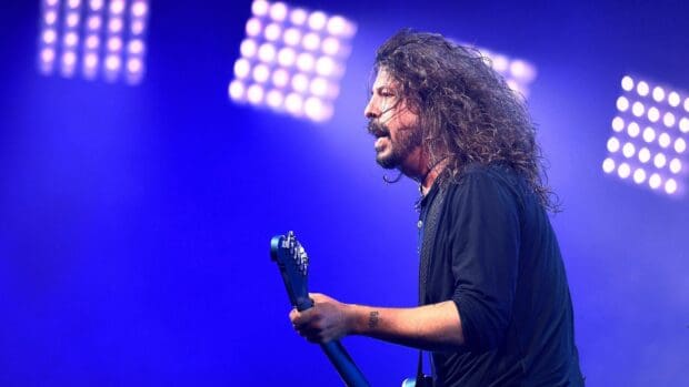 Dave Grohl is performing on stage with guitar under blue lights, HD Desktop Wallpaper
