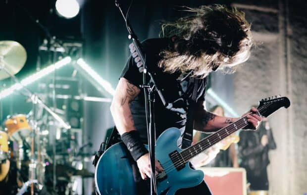 Dave Grohl is performing live on stage playing a blue guitar with hair flying, HD Desktop Wallpaper
