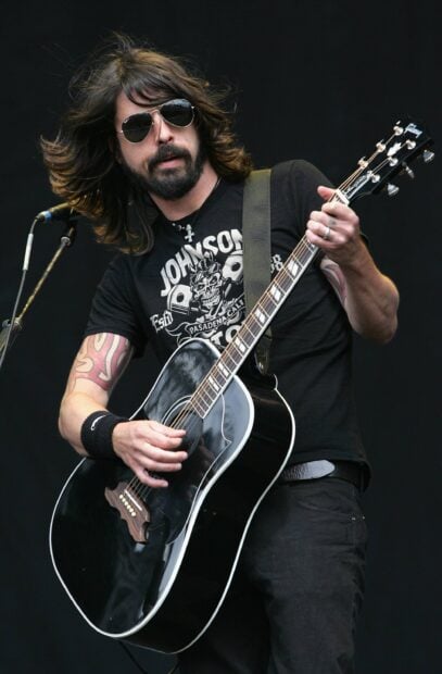 Dave Grohl is playing an acoustic guitar during a live performance, 2K Desktop Wallpaper