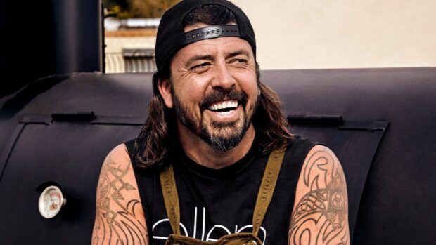 Dave Grohl smiles warmly showing his tattoos on his arms, 2K Desktop Wallpaper