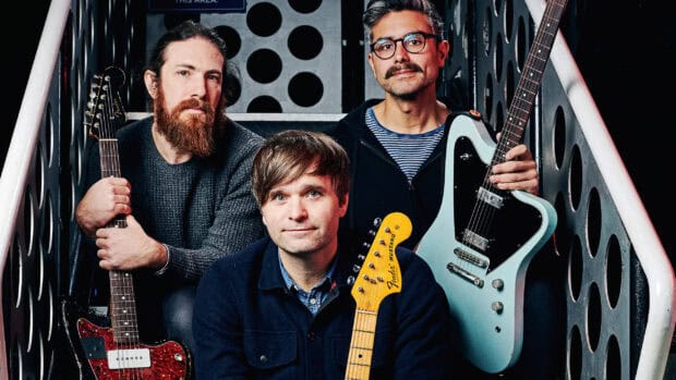Death Cab For Cutie band members sitting with guitars in a music studio, 2K Desktop Wallpaper