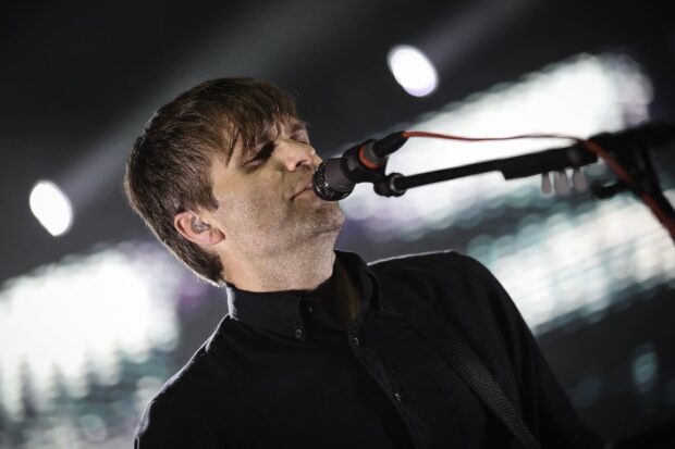 A male singer from Death Cab For Cutie performs passionately on stage, HD Desktop Wallpaper