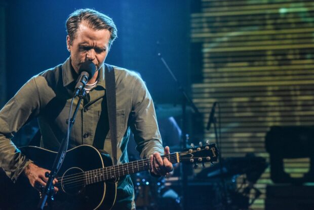 A man is singing and playing guitar on stage during the Death Cab For Cutie concert, 2K Desktop Wallpaper