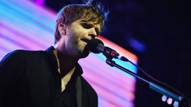 A close up of a band member singing passionately into a microphone during a concert, HD Desktop Wallpaper