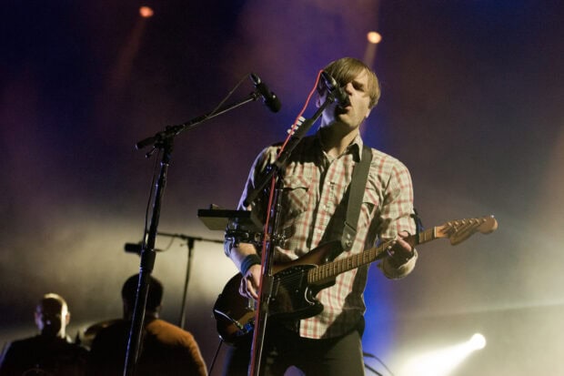 A musician from Death Cab For Cutie sings and plays guitar on stage, HD Desktop Wallpaper