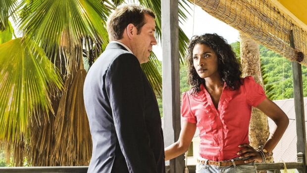 A man and woman having a conversation outdoors surrounded by tropical plants in Death In Paradise TV Series, HD Desktop Wallpaper