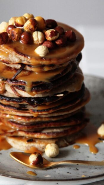 A close up of a stack of pancakes topped with caramel sauce and nuts on a plate, 4K Mobile Wallpaper