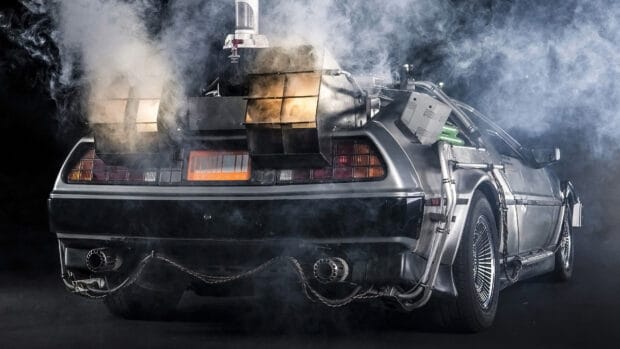 The Delorean DMC 12 emits smoke from its rear in a dark setting, 4K Desktop Wallpaper