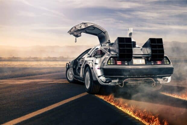 A Delorean DMC 12 is shown leaving fiery trails on an open road at sunset, HD Desktop Wallpaper