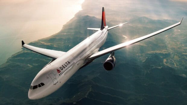 A Delta Air Lines airplane soars above a scenic coastline during sunset in this Delta Air Lines Wallpapers, HD Desktop Wallpaper PC Wallpaper