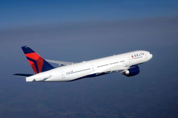 A Delta Air Lines airplane is flying above the landscape with a clear blue sky, HD Desktop Wallpaper