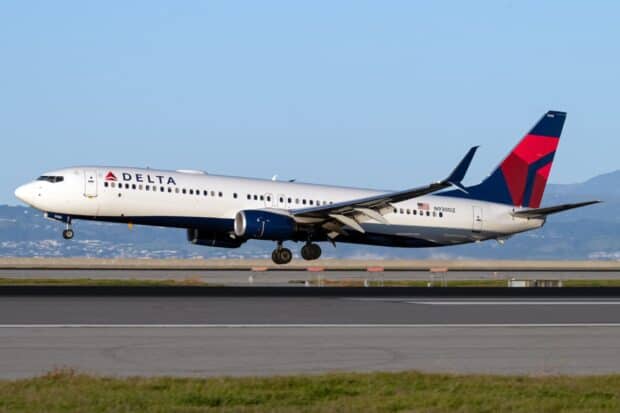 A Delta Air Lines airplane is landing on the runway with clear sky, HD Desktop Wallpaper