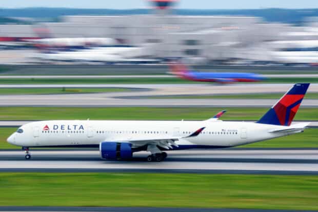 A Delta Air Lines airplane is taxiing on the airport runway with motion blur in the background, HD Desktop Wallpaper