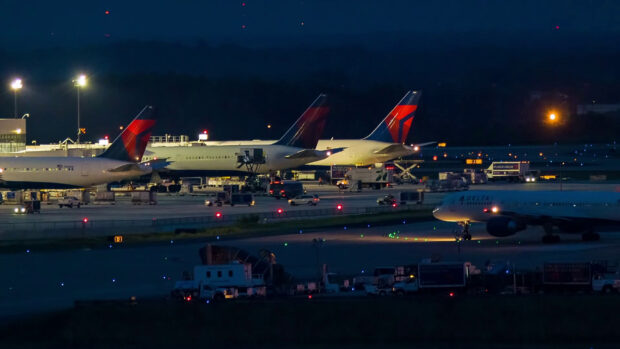 Delta Air Lines airplanes are parked on the runway during nighttime operations, HD Desktop Wallpaper
