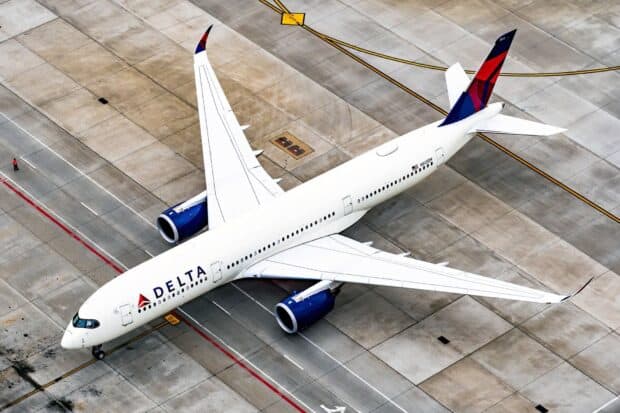 A Delta Air Lines jet is parked on a concrete runway surrounded by airport markings, HD Desktop Wallpaper