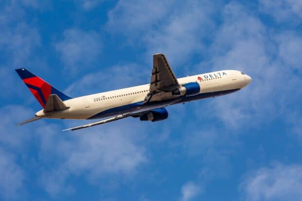 A Delta Air Lines plane is captured soaring through a clear blue sky, HD Desktop Wallpaper