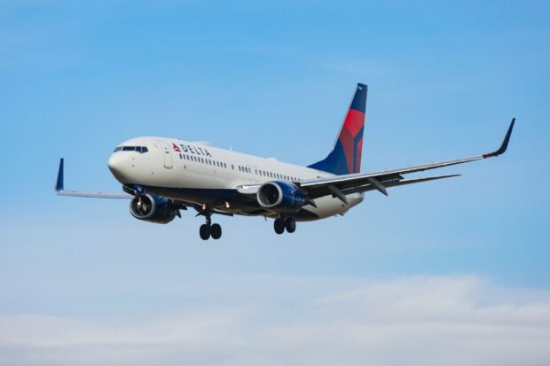 A Delta Air Lines plane is captured flying under a clear blue sky, HD Desktop Wallpaper